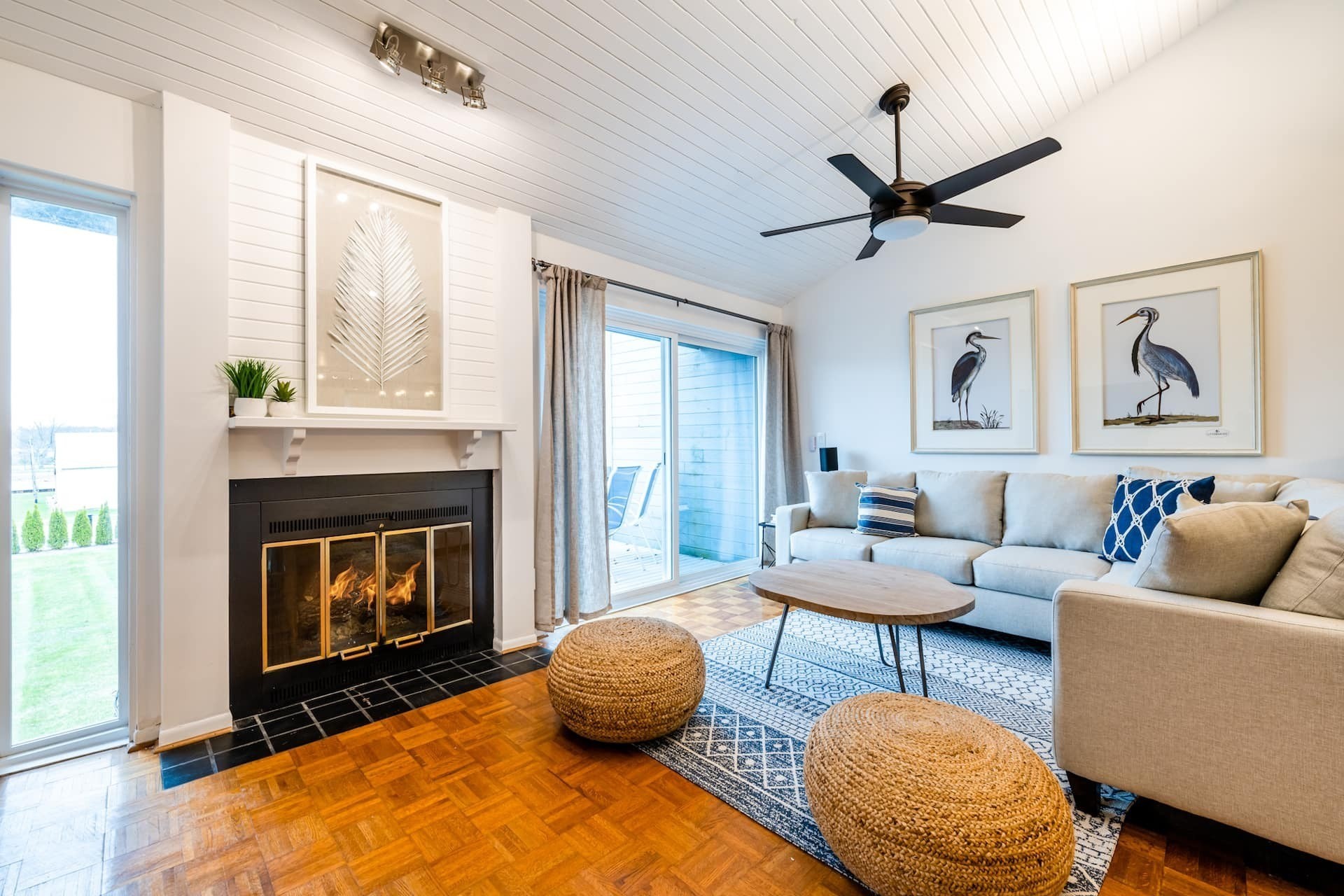 A furnished living room with fireplace, vaulted ceiling, and seating